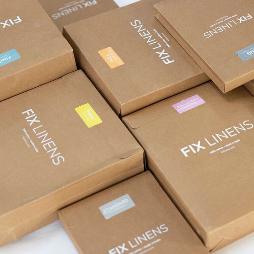 a group of recyclable, brown cardboard boxes with different colored stickers indicating sheet and duvet cover sizes