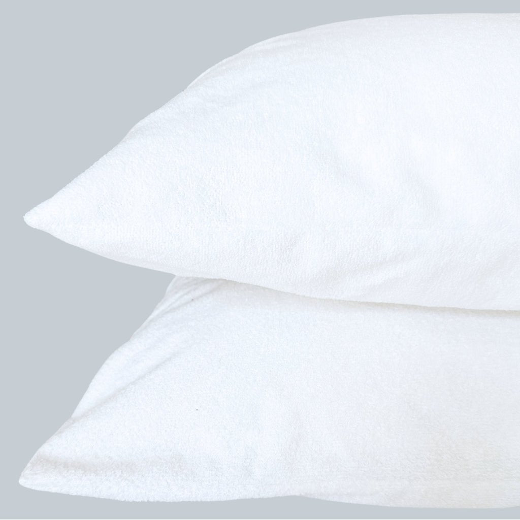 Two stacked standard pillows with Fix Linens white waterproof breathable pillow protectors showing smooth, fitted design.