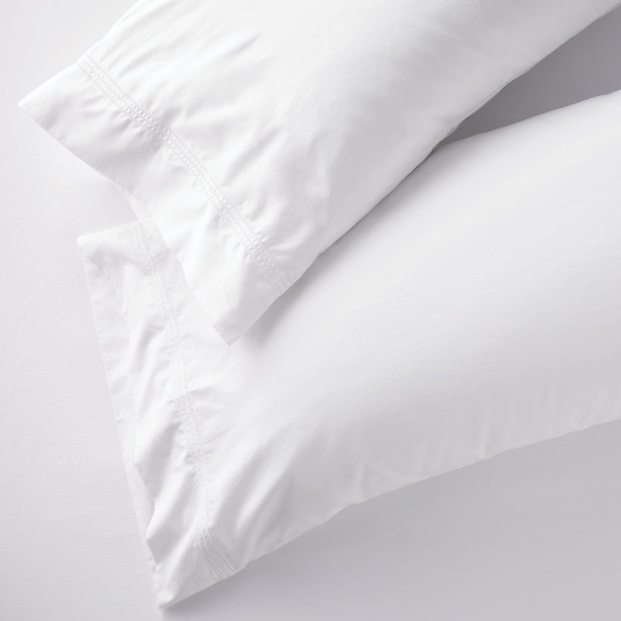 Set of two white king pillowcases with embroidered size line in 400-thread-count cotton, perfect for Airbnb beds