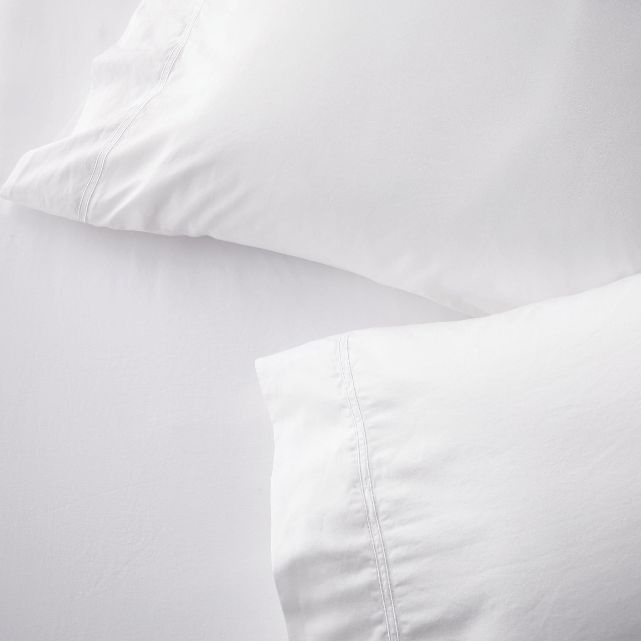Set of two white standard pillowcases with embroidered size line, soft cotton ideal for vacation rentals