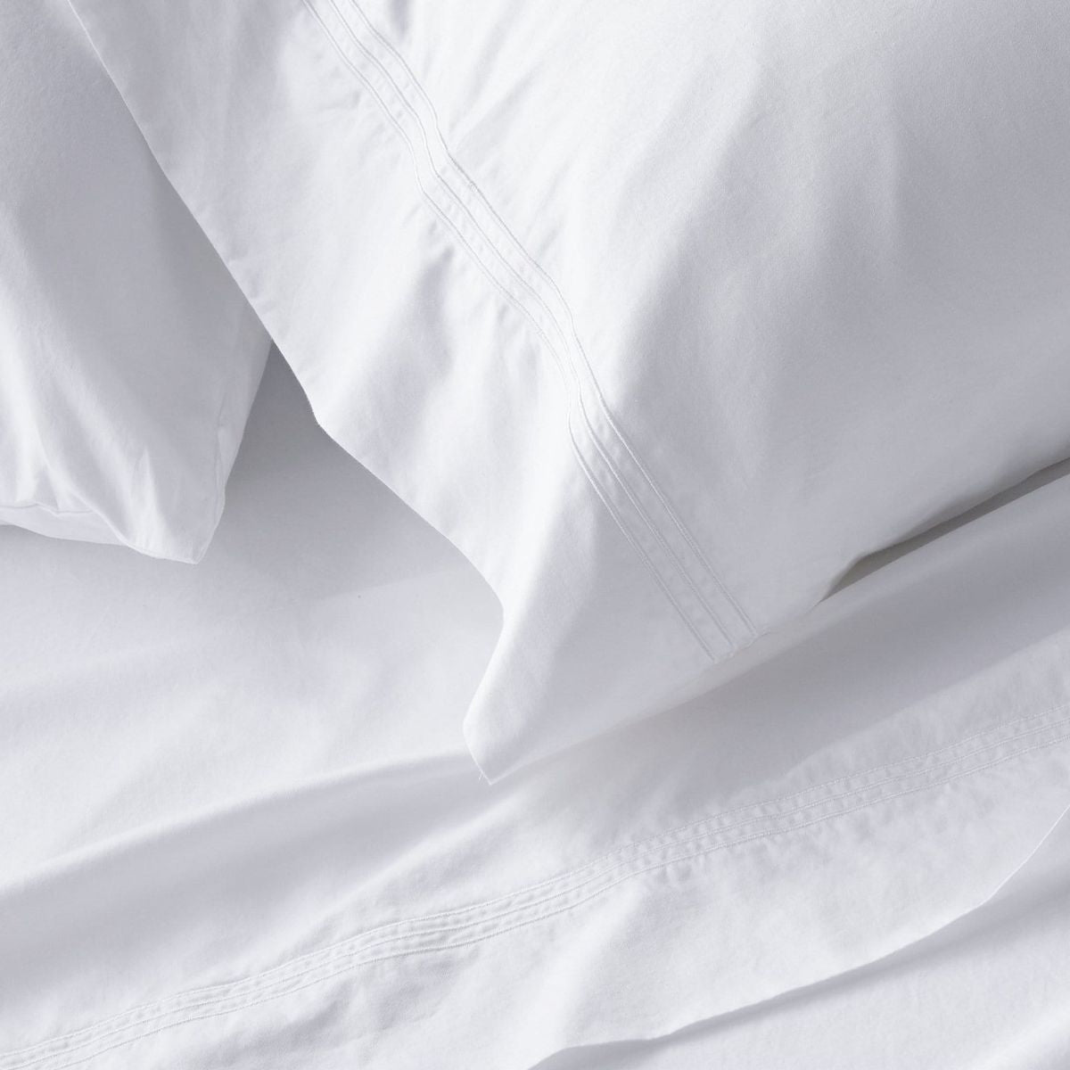 King sheet set lifestyle in white cotton, detail view for Airbnb hosts