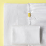 White twin cotton sheet set with color-coded tags and embroidered size lines for easy Airbnb turnovers