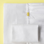 twin sheet set folded, flat sheet has no embroidery, fitted sheet has a small yellow tag with the word twin, 2 standard pillowcases no embroidery